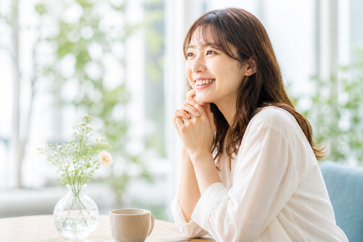 明るい室内で笑顔を見せる女性